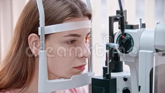 眼科医生坐在眼科检查仪器旁等待的妇女视频的预览图