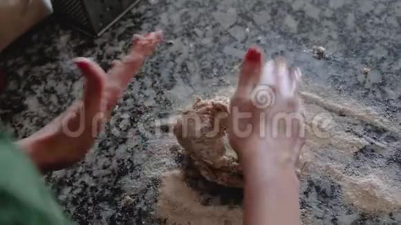 女人在翻转的台面上用圆形的动作揉捏全麦面团视频的预览图