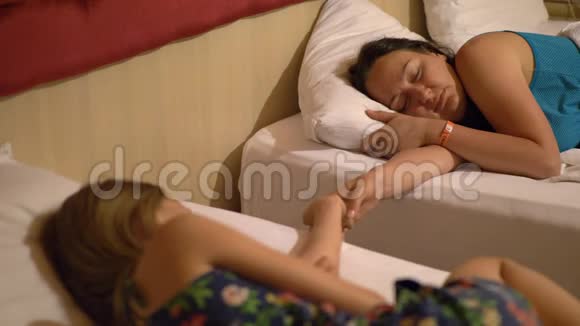 冷静美丽的年轻女人牵着手睡在酒店房间里视频的预览图