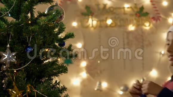 快乐的小男孩装饰和玩圣诞树视频的预览图