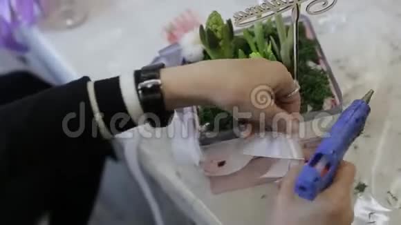 戴着红色橡胶手套的女人用胶带粘在花盆上视频的预览图