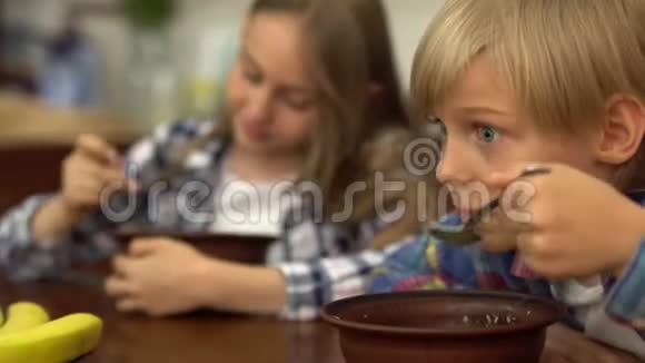 早上在厨房里吃麦片的可爱孩子的肖像健康美味的早餐视频的预览图