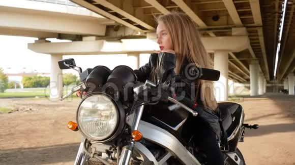 穿黑色摩托车皮夹克的少女骑摩托车的比基尼女郎在漂亮的摩托车上视频的预览图