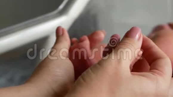 宝宝的脚在妈妈手里小新生婴儿脚在女性心脏整形的手特写母亲和她的孩子视频的预览图