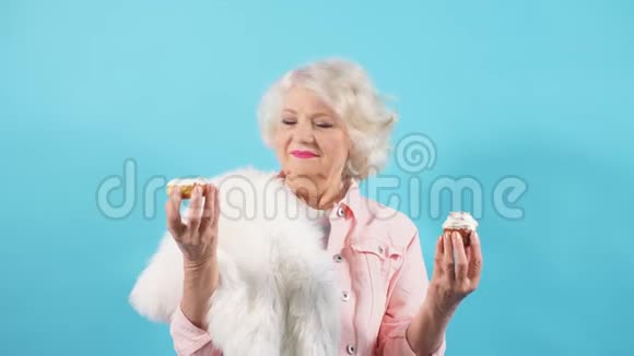快乐令人敬畏的祖母独自庆祝她的生日奶奶举起双手提供甜点视频的预览图