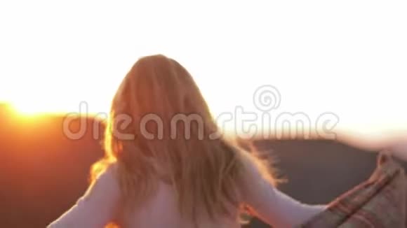 年轻女性迷人的女孩旅行者博客在夕阳下的阳光山上散步和跳舞穿着温暖的衣服视频的预览图