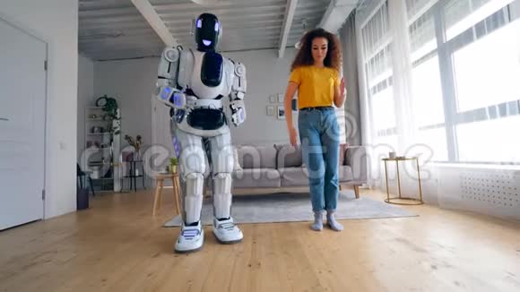 年轻的女人和机器人在跳舞机器人人形半机概念视频的预览图