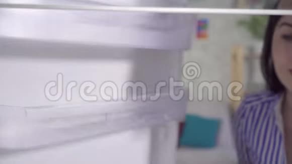 戴手套的年轻女人洗冰箱视频的预览图