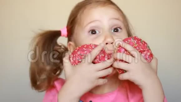 孩子吃甜甜圈特写小女孩吃甜甜圈加糖美味的甜的甜的视频的预览图