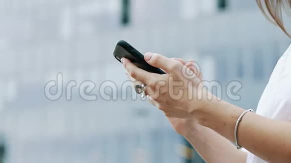 女商人手持现代手机发短信与朋友聊天的特写视频的预览图