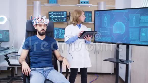 女性医生检查男性患者的脑部活动视频的预览图