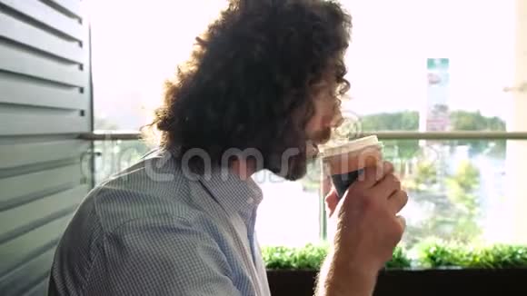 孤独悲伤的人在咖啡店里用纸帽喝咖啡坐在靠近木墙的地方面对障碍视频的预览图