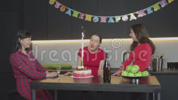 生日蛋糕上吹蜡烛的快乐女人视频的预览图