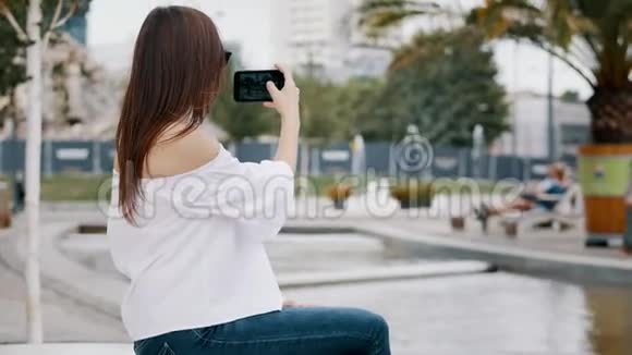 女游客使用手机为游客博客拍照或录制城市景观视频视频的预览图