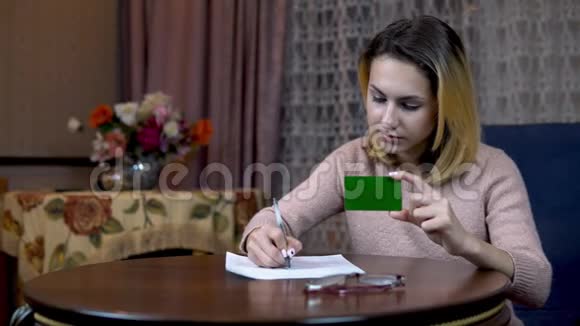 有信用卡和文件的女孩将卡片数据填充在一张纸上绿色屏幕视频的预览图