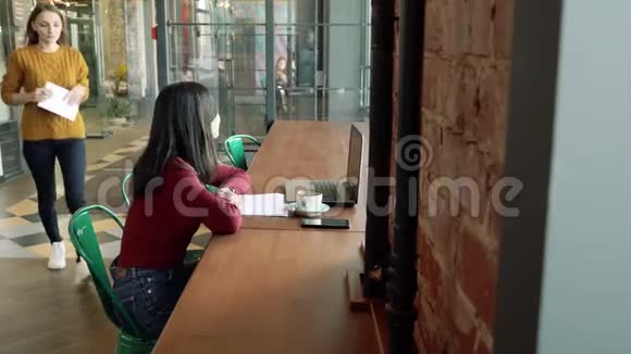 两个年轻女人在咖啡馆或办公室里互相问候视频的预览图