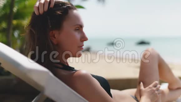 在海边晒黑的年轻女子视频的预览图