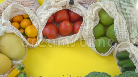 五颜六色的水果和蔬菜在可重复使用的袋子在黄色的背景零浪费减少塑料废物概念视频的预览图