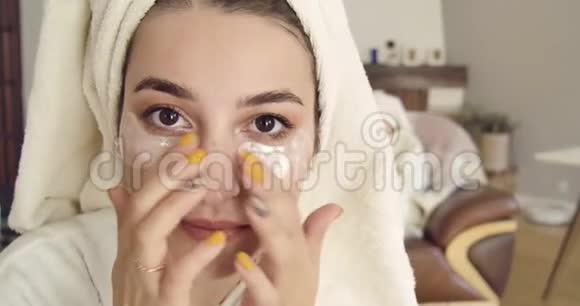 一个可爱的白种人女人的特写脸棕色的眼睛在发巾上涂上眼胶补丁同一个女孩视频的预览图