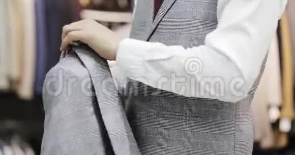 一个穿背心的商人在笼子里穿上灰色夹克视频的预览图