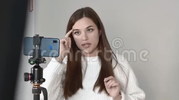 白种人女博主站在镜头前的手机上说笑视频的预览图