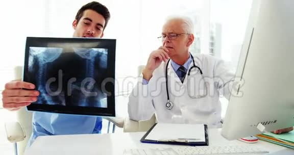 男性医生和同事检查x光视频的预览图
