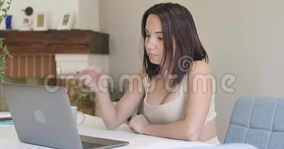 一幅年轻体贴的高加索女人坐在桌子旁的笔记本电脑上打字的肖像网上工作的漂亮女孩视频的预览图