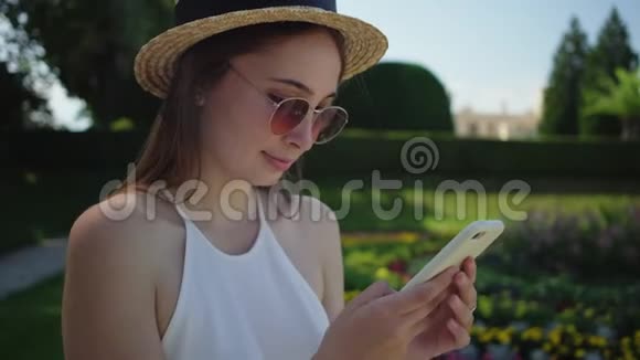 莱德尼斯宫花园里有智能手机的女人视频的预览图