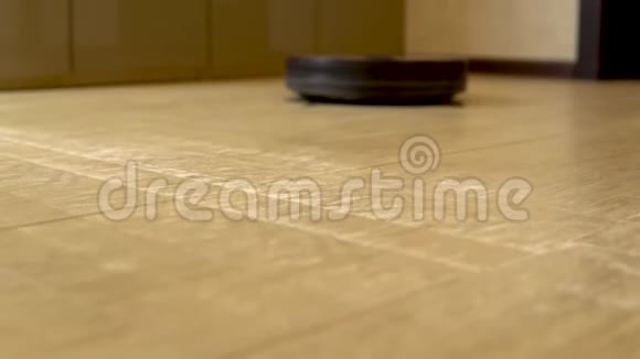 机器人吸尘器正在打扫房间一个圆形的吸尘器会自动在房子周围转动并清洁视频的预览图