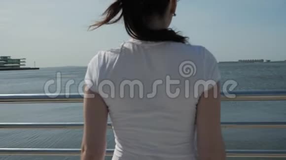 女人站在长廊上享受无边的海景视频的预览图