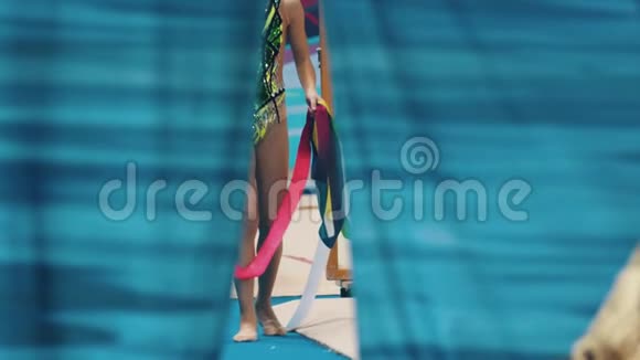 在艺术体操比赛中年轻女子的腿从舞台上走出来拿着她们的特殊物品视频的预览图