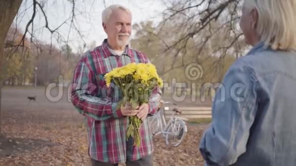 快乐的白种人成熟男人给他可爱的妻子菊花花束跪下欧洲成熟视频的预览图