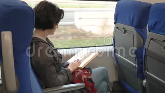 白种人女人坐火车靠窗读书火车停在站台上视频的预览图