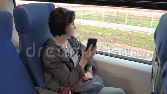 一个女人坐在火车上打电话视频的预览图