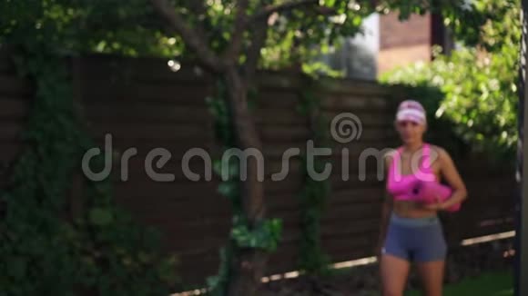 年轻的运动女性带着健身垫来健身慢动作视频的预览图
