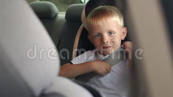 一个6岁的小男孩坐在汽车座椅上他系着安全带视频的预览图