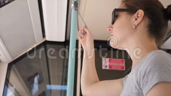 女孩站在电车上去市中心的低角度拍摄视频的预览图
