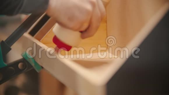 木工工人工人在木材上涂胶用胶合板制作木制组织者视频的预览图