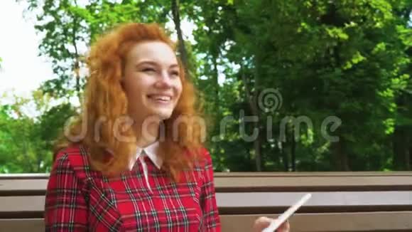 乔维亚红头发女孩嘲笑公园里的有趣的书视频的预览图