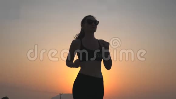活泼苗条的女孩在乡间小路上慢跑背景是夜空女运动员做跑步训练青年视频的预览图