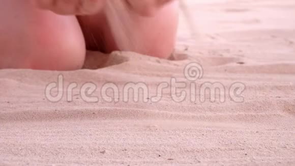 沙滩上的沙子从女人的手视频的预览图