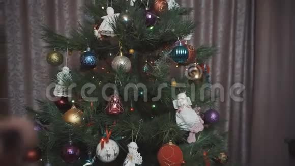 一个女孩在圣诞树的背景上端着一杯酒视频的预览图
