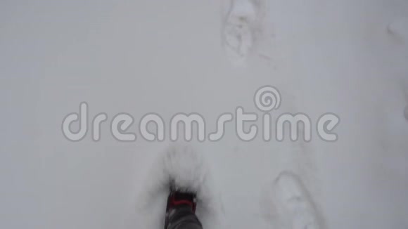 一个男人穿着夏天的运动鞋穿过雪地视频的预览图