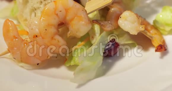 烤虾放在白色盘子里上面有烤面包柠檬和酱汁百里香枝沙拉叶视频的预览图