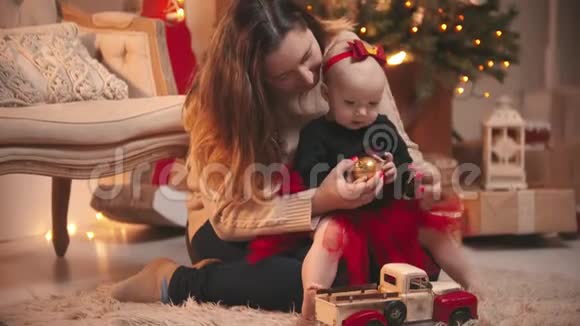 圣诞节概念一个女人和她的小女儿玩圣诞球视频的预览图
