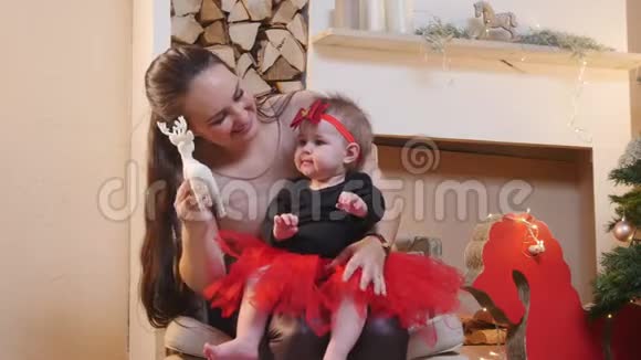 圣诞节概念一个女人和她的小女儿玩玩具鹿视频的预览图