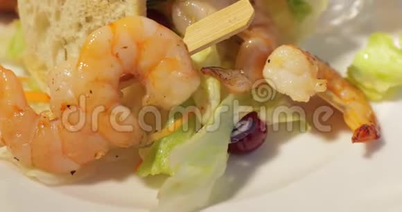 烤虾放在白色盘子里上面有烤面包柠檬和酱汁百里香枝沙拉叶视频的预览图