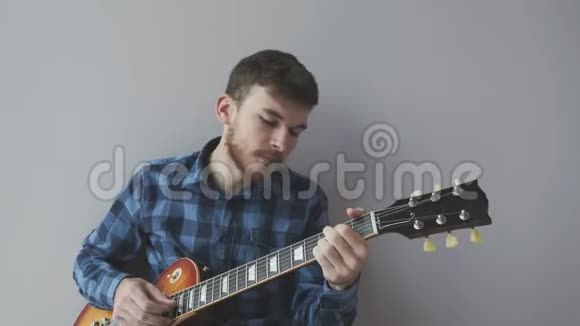悲伤的年轻人留着胡子拿着电吉他在摇滚音乐会前演奏一首摇滚民谣音乐乐器概念视频的预览图