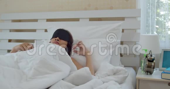 亚洲年轻女子醒来触摸闹钟视频的预览图