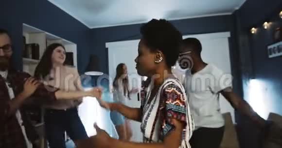 快乐的年轻快乐的黑人千禧一代和多民族的朋友在史诗般有趣的节日聚会上跳舞慢动作视频的预览图
